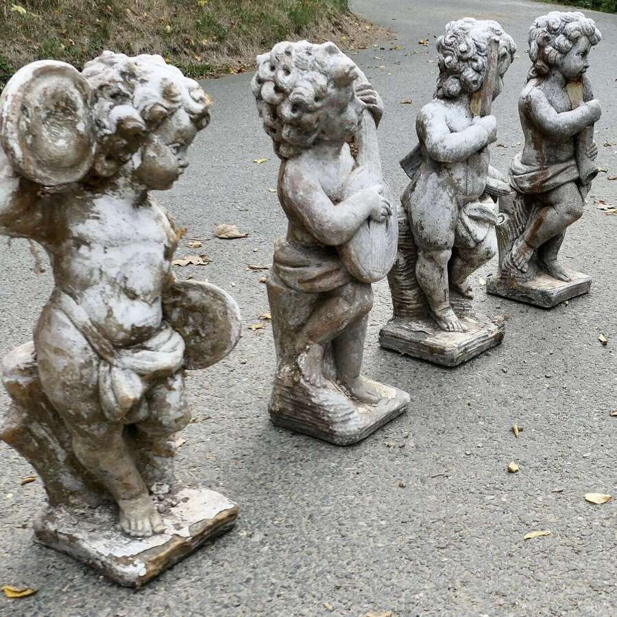 A Set of 4 Weather Worn Cherub Statues with Instruments