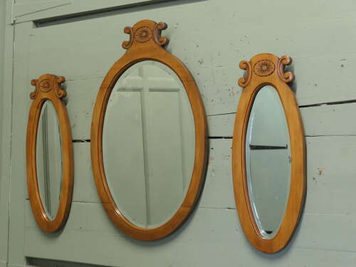 A Trio of Oval Satin Walnut Wall  Mirrors  The largest mirror is set off